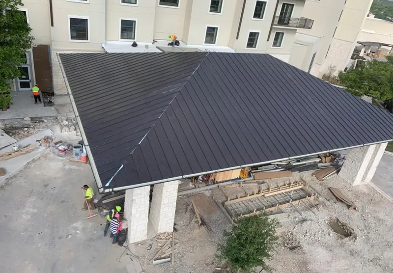 Metal roofing installation team working on a commercial building in Emerson